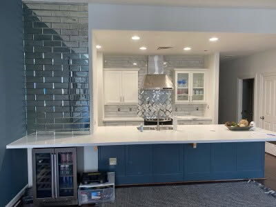 Kitchen with navy blue island, wine cooler and white cabinets